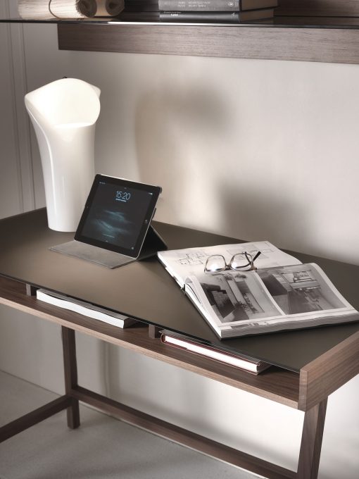 Writing desk with solid walnut-stained ash structure and mocha-colored glass top.