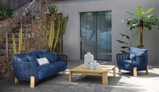 Salon d'extérieur de luxe en bois naturel et revêtement bleu. Vente en ligne de meubles de jardin, canapé, fauteuil haut de gamme avec livraison gratuite.