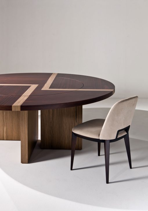 Raffinatezza senza ostentazione. Ampio piano rotondo con meccanismo girevole centrale a filo (Lazy Susan). Tavolo in legno intarsiato. Bartoli Design.