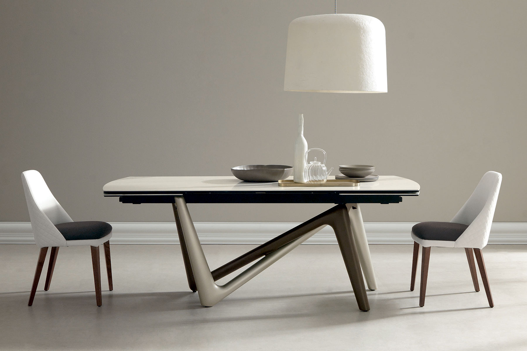 Andrea Lucatello designed a high-end ceramic extensible table, customizable in several finishing. Bicolor base, aluminium frame and barrel-shaped top.