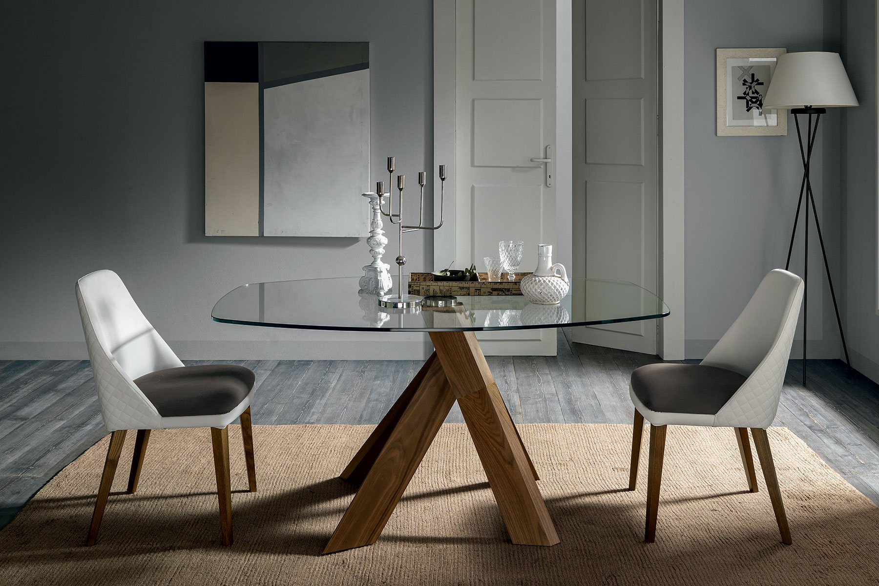 Design Arter & Citton. La base del tavolo a botte richiama le radici di un albero. Il piano trasparente poggia su un solo ed elegante punto di equilibrio.