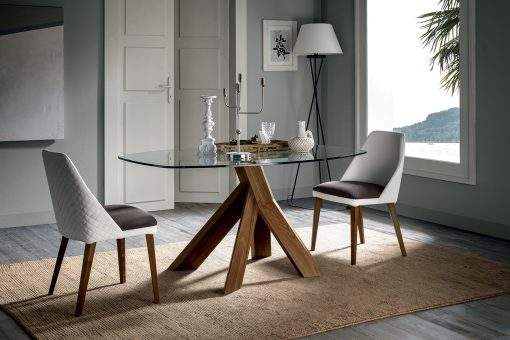 Design Arter & Citton. La base del tavolo a botte richiama le radici di un albero. Il piano trasparente poggia su un solo ed elegante punto di equilibrio.