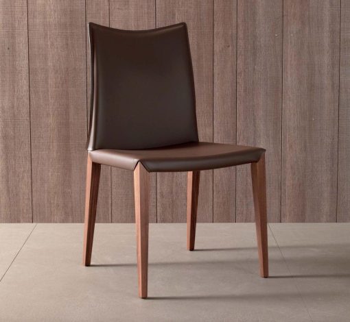 Flory est une chaise en frêne au design linéaire réalisée en Italie. Cette chaise de salle à manger haut de gamme est disponible en eco-cuir ou velours.