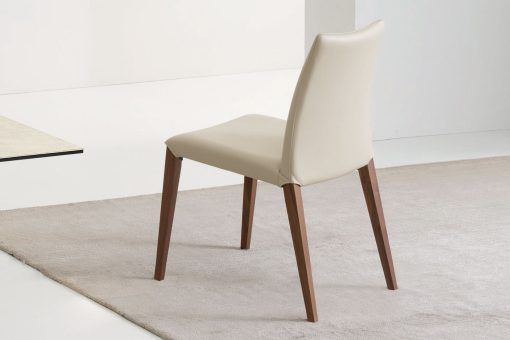 Flory est une chaise en frêne au design linéaire réalisée en Italie. Cette chaise de salle à manger haut de gamme est disponible en eco-cuir ou velours.