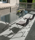 Outdoor rectangular table with a lava stone top and sculptural stainless steel base. Made in Italy. Online shopping and free home delivery.