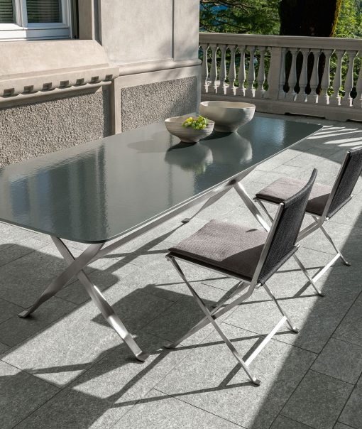 Outdoor rectangular table with a lava stone top and sculptural stainless steel base. Made in Italy. Online shopping and free home delivery.