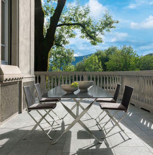 Outdoor rectangular table with a lava stone top and sculptural stainless steel base. Made in Italy. Online shopping and free home delivery.