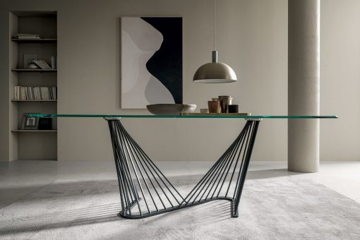 A luxurious table with barrel glass top and metal sinuous base. Andrea Lucatello created it to furnish the most elegant homes. Free home delivery.