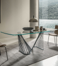 A luxurious table with barrel glass top and metal sinuous base. Andrea Lucatello created it to furnish the most elegant homes. Free home delivery.