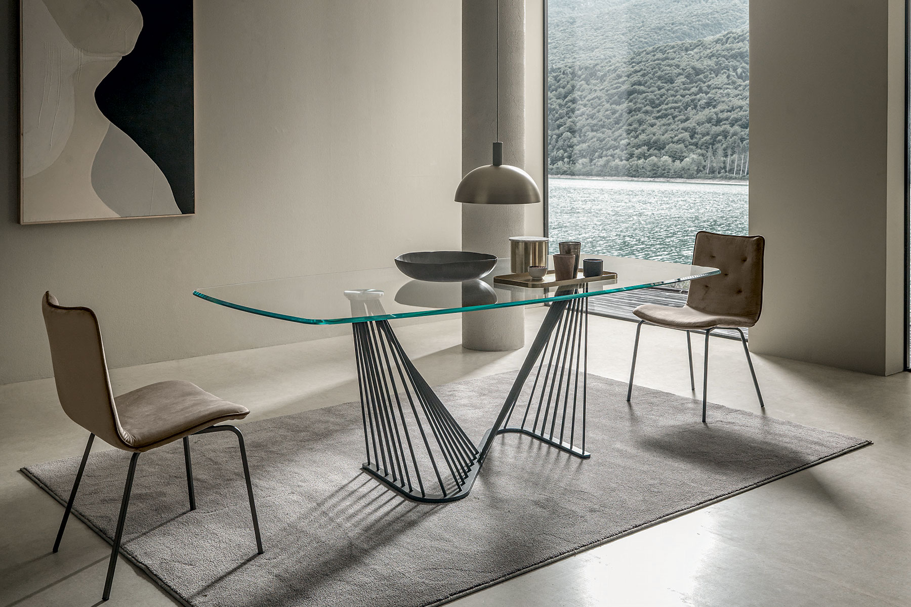 A luxurious table with barrel glass top and metal sinuous base. Andrea Lucatello created it to furnish the most elegant homes. Free home delivery.