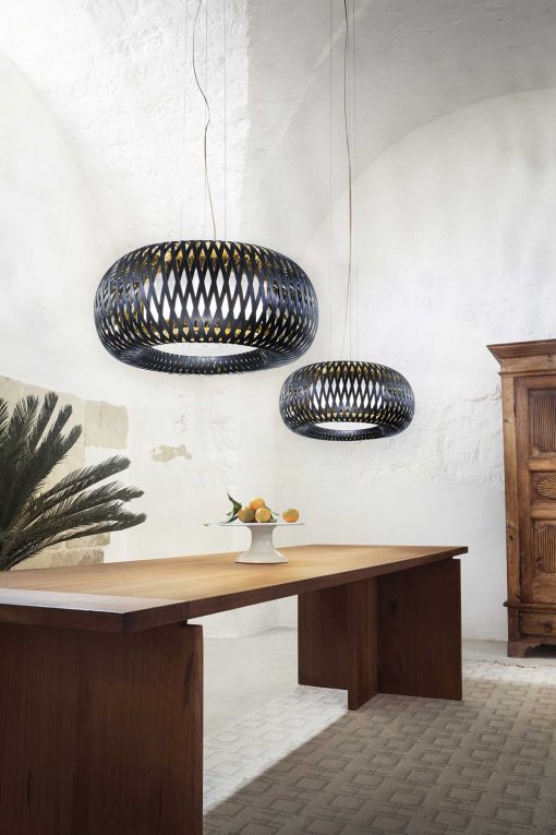 Art of weaving and technical performance. A round scenographic black pendant lamp designed by Elisa Giovannoni. Worldwide home delivery.