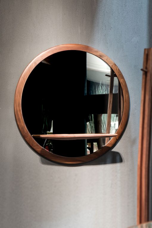 MIRAGGIO est un miroir rond raffiné et élégant. Cadre en noyer Canaletto massif, étagère pour petits objets, made in Italy. Livraison à domicile offerte.