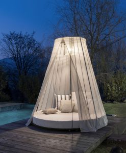 Majestueux et luxueux daybed de jardin. Matelas rond, structure en acier et bois, cordes nautiques et légers rideaux. Suspension lumineuse intégrée.