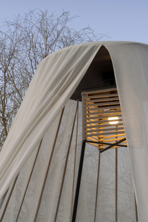 Majestueux et luxueux daybed de jardin. Matelas rond, structure en acier et bois, cordes nautiques et légers rideaux. Suspension lumineuse intégrée.