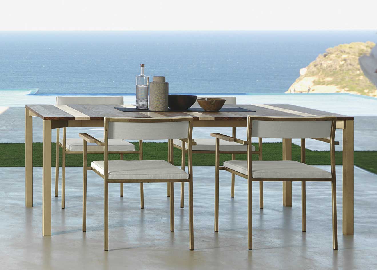 Garden table with stainless steel frame. Top in iroko wood and travertine. Patio furniture design by Ramon Esteve. Shop online for outdoor table and chairs.