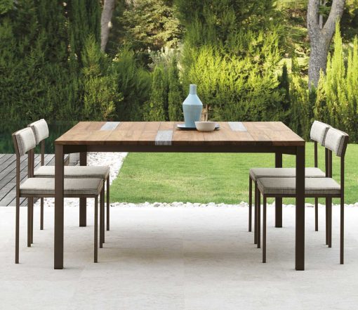 Garden table with stainless steel frame. Top in iroko wood and travertine. Patio furniture design by Ramon Esteve. Shop online for outdoor table and chairs.