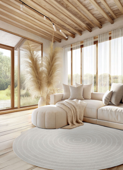 Cortina Sfera Ivory round rug with light wood and brass accents