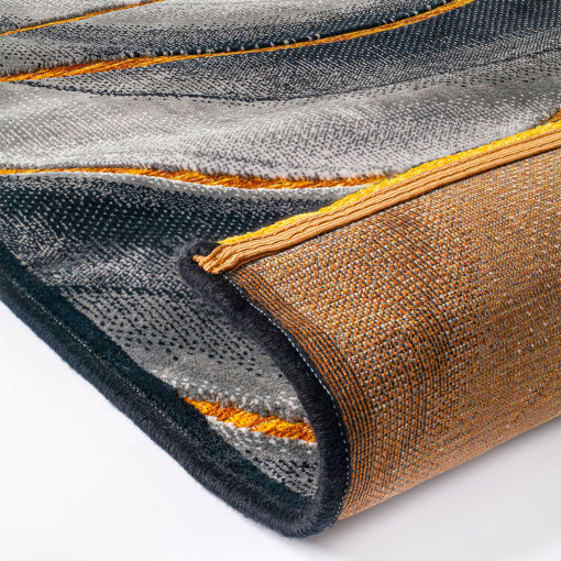 Close-up of 3D wave motif and yellow-orange accents on Gabrielle Waves Grey Yellow rug