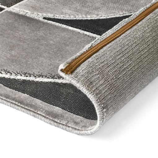 Close-up of intersecting straight and curved lines on grey rug
