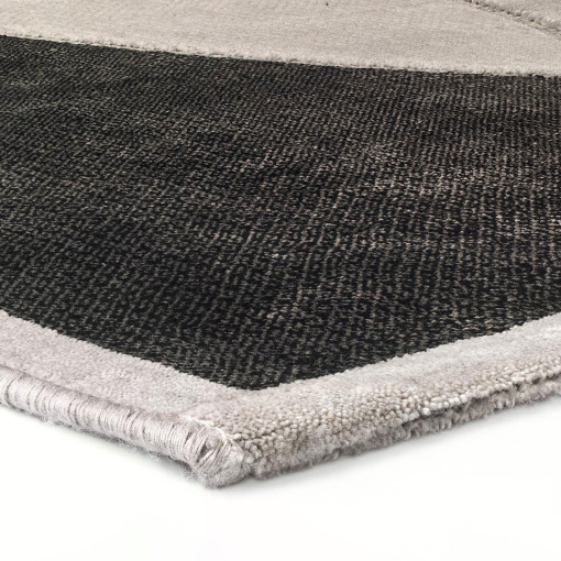 Close-up of intersecting straight and curved lines on grey rug