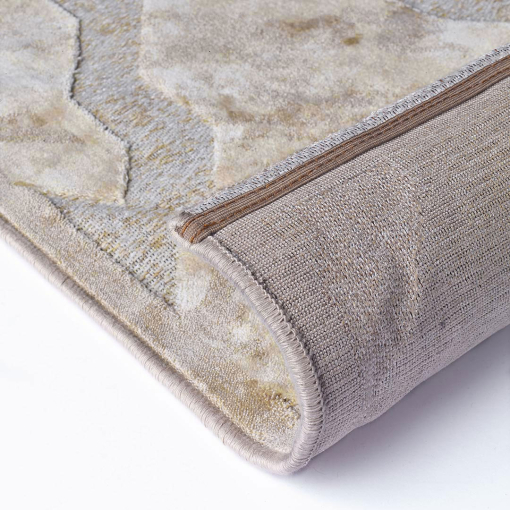 Close-up of interlacing curved lines in light gold on Gabrielle rug