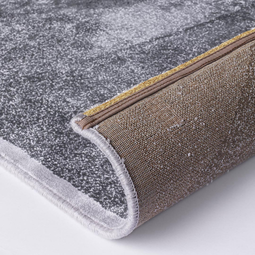Close-up of stylised golden hexagonal lines on grey rug