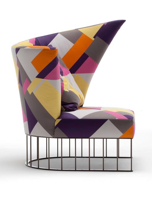 A curved shape luxurious armchair with patterned fabric and chrome steel base. A very suggestive high-quality piece of furniture. Free delivery.