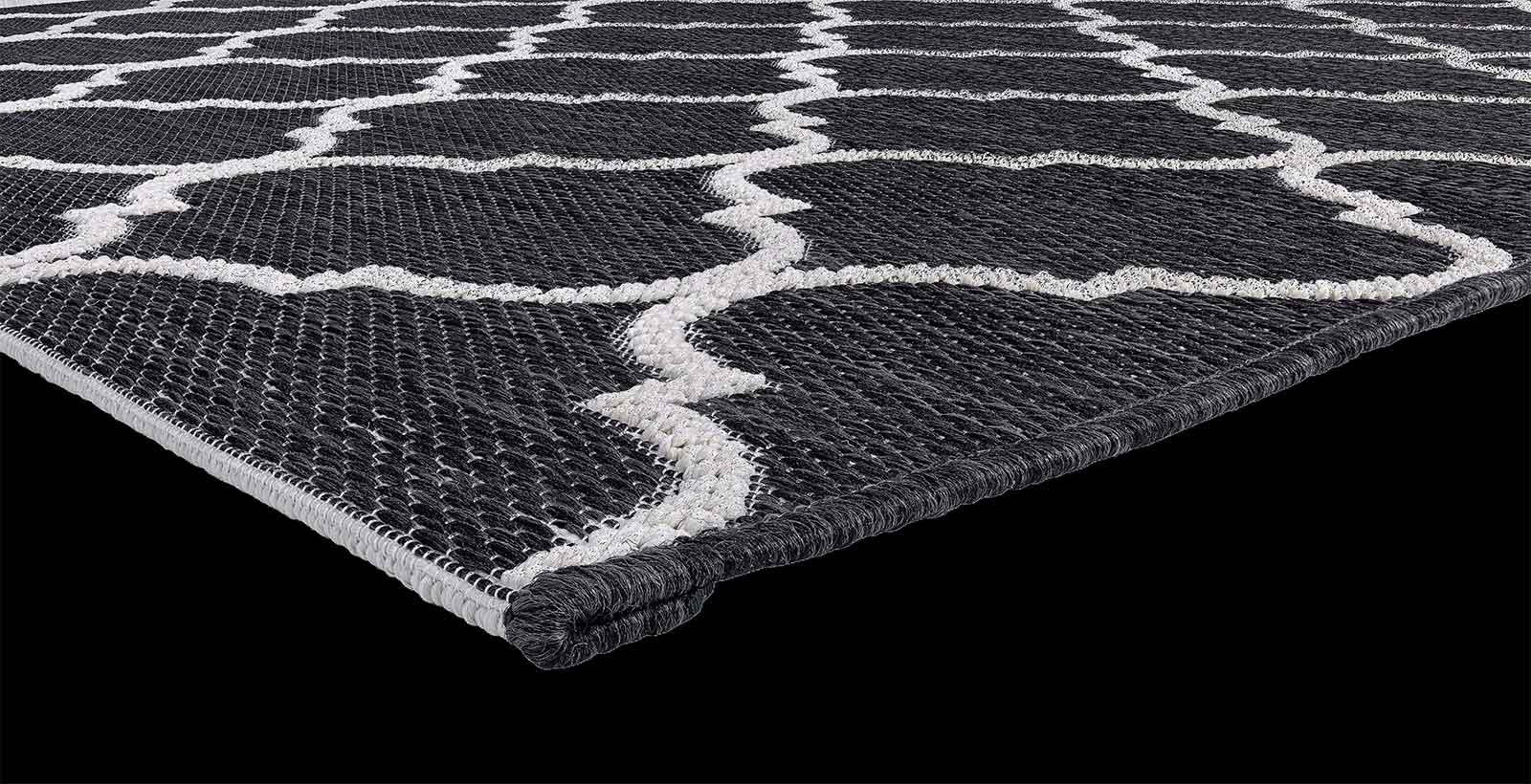 Motivi geometrici, dominante nera. Un tappeto rettangolare da esterno 100% polipropilene pratico e resistente.